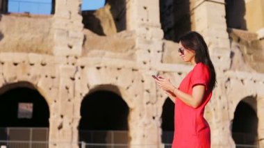 Roma, İtalya elinde akıllı telefon ile genç kadının önünde Colosseum. Europe tatil kız