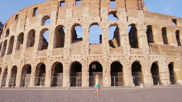 Entzückendes kleines aktives Mädchen, das sich vor dem Kolosseum in Rom amüsiert. Kind verbringt Kindheit in Europa — Stockvideo