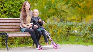 Sevimli küçük kız annesi ile sonbahar günü sonbahar park açık havada keyfini çıkarın