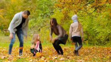 Bir sonbahar günü açık havada üzerinde çevresinde aile atma gülümseyen genç yaprakları