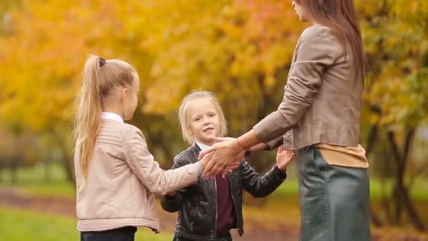 Νεαρή μητέρα και δύο κόρες λίγο παίζοντας παιχνίδια στο πάρκο φθινόπωρο — Αρχείο Βίντεο