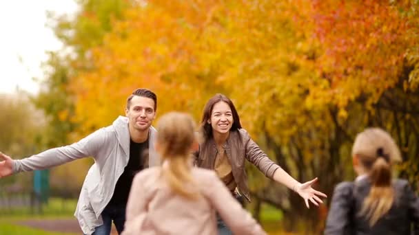 Jong gezin met kleine kinderen in herfst park genieten van warme dag — Stockvideo