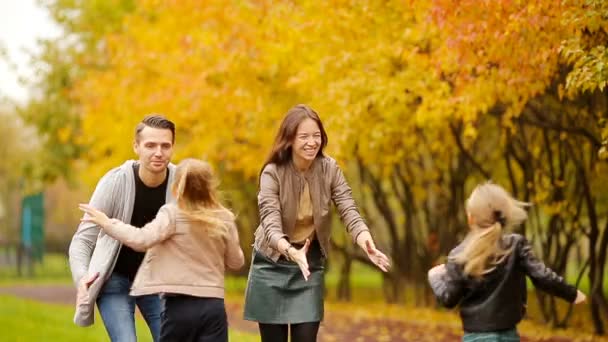 Junge Familie mit kleinen Kindern im Herbstpark an sonnigem Tag — Stockvideo