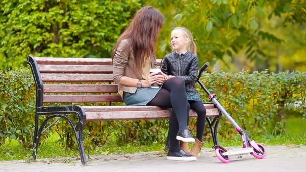 Urocza dziewczynka z Mama cieszyć dzień jesieni w jesienny park na zewnątrz — Wideo stockowe