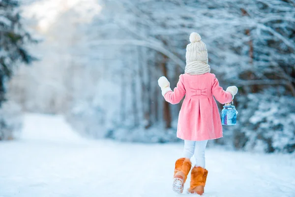 Petite fille avec lampe de poche dans la forêt gelée la veille de Noël — Photo