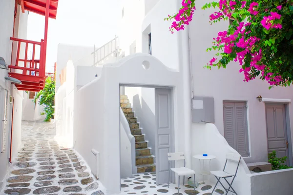 The narrow streets with blue balconies, stairs, white houses and flowers in beautiful village in Greece. Beautiful architecture building exterior with cycladic style in Mykonos — Stock Photo, Image