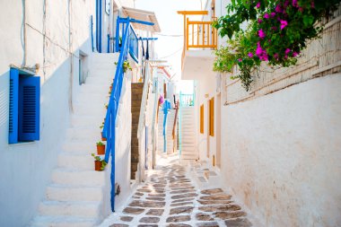 Mavi balkon, merdiven ve çiçekler ile Yunan Adası dar sokaklarında. Bina dış Kiklad tarzı ile güzel mimari.