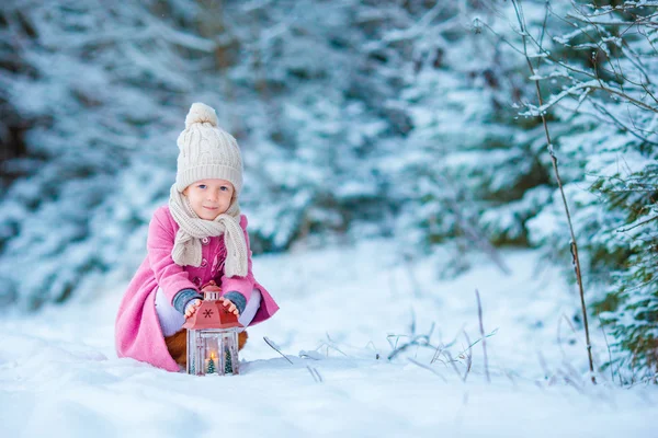 Adorable petite fille portant un manteau chaud à l'extérieur le jour de Noël réchauffe les mains froides par lampe de poche — Photo