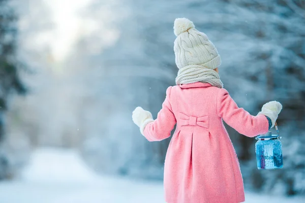 Niña sosteniendo linterna de Navidad al aire libre en hermoso día de nieve de invierno — Foto de Stock