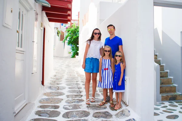 Familjesemester i Europa. Föräldrar och barn på gatan av typiska grekiska traditionella byn på ön Mykonos i Grekland — Stockfoto