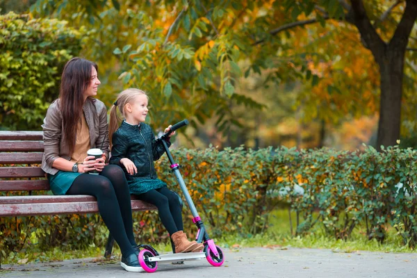 Adorable niña con mamá disfrutar del día de otoño en el parque de otoño al aire libre — Foto de Stock