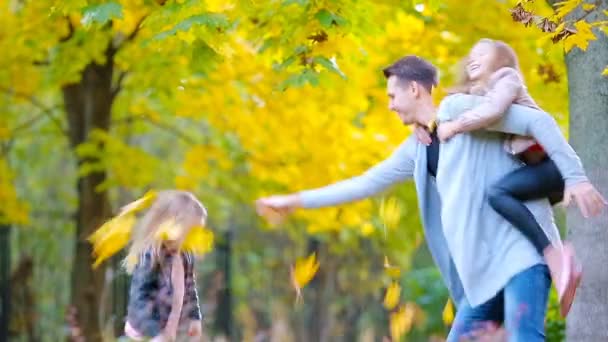 Счастливая семья в осеннем парке наслаждается теплым днем — стоковое видео