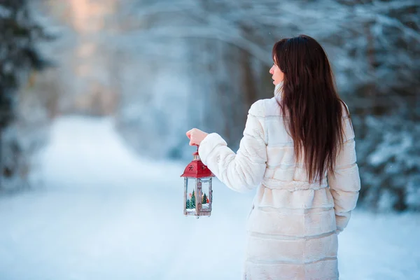 Girl holding Christmas lantern outdoors on beautiful winter snow day — Stock Photo, Image