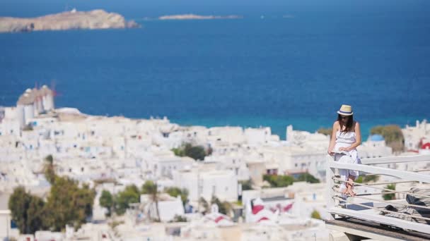 Linda jovem leitura livro em hotel de luxo com vista incrível sobre Mykonos, Grécia — Vídeo de Stock
