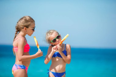 Plajda dondurma yeme mutlu küçük kızlar.