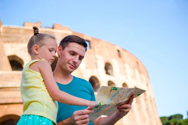 Family with map in front of Colosseum. Father and girl searching the attraction background the famous area in Rome — Stock Photo, Image