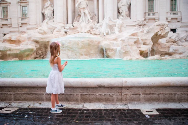 Очаровательная маленькая девочка у фонтана Треви в Риме. Счастливая малышка наслаждается своим европейским отпуском в Италии — стоковое фото