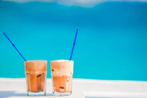 Frappe, café gelado na praia. Frappuccino de café gelado de verão, frappe ou latte em um fundo de vidro alto o mar no bar da praia — Fotografia de Stock