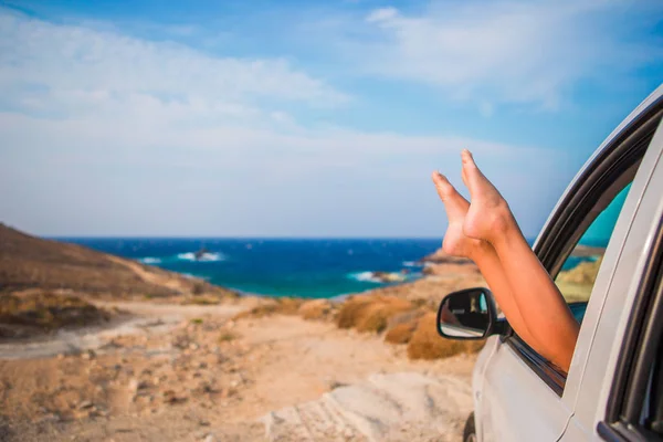 Zomer vakantie, reizen, vakantie, weg reis en mensen concept - close up van weinig meisje voeten tonen van autoruit — Stockfoto