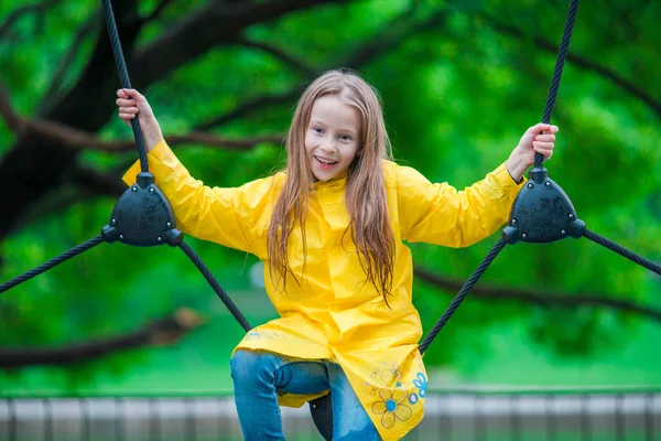 Fröhliches kleines Mädchen spielt auf Spielplatz im Freien — Stockfoto