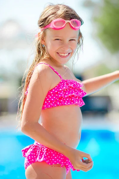 Sorrindo menina feliz em óculos para nadar na piscina exterior — Fotografia de Stock