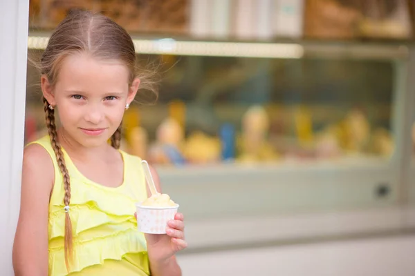 Adorable niña comiendo helado al aire libre en verano. Lindo niño disfrutando de helado italiano real cerca de Gelateria en Roma —  Fotos de Stock