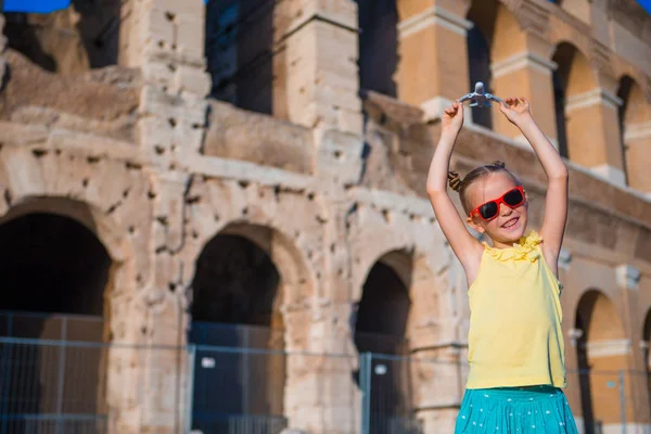 Kız ile küçük oyuncak model uçak Colosseo arka planda Roma, İtalya
