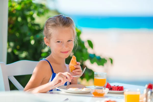 Hora del almuerzo. Niña desayunando en la cafetería al aire libre con vista al mar —  Fotos de Stock