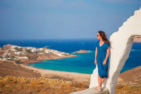 Mladá žena a tradiční bílý kostel s výhledem na moře na ostrově Mykonos, Řecko — Stock fotografie