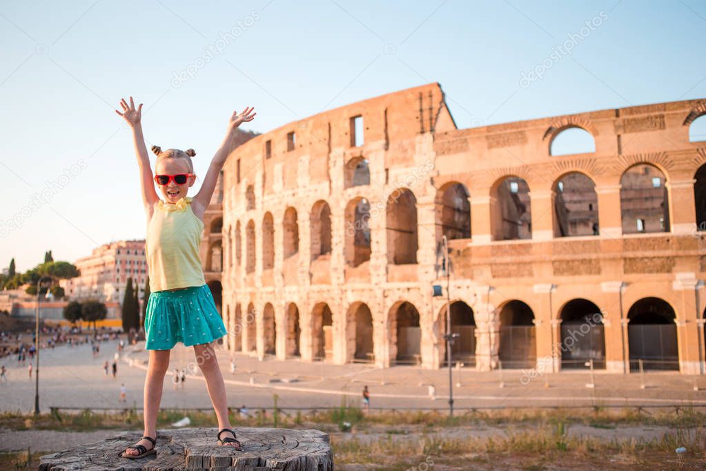 Adorable little active girl having fun in front of Colosseum in Rome, Italy.