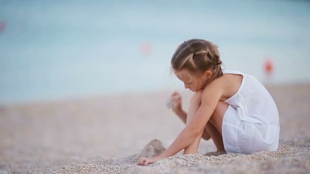 Entzückendes kleines Mädchen spielt am Strand — Stockvideo