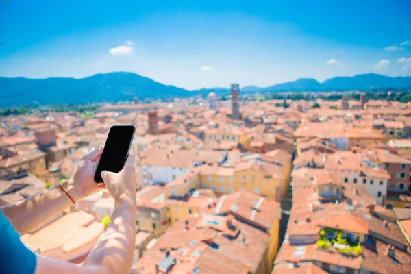 Closeup mužských rukou drží mobil pozadí starého italského města. Člověk používající mobilní smartphone. — Stock fotografie