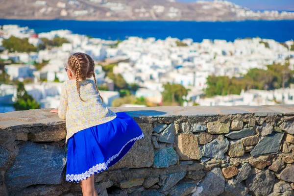 Rozkošná holčička v městě Mykonos pozadí úžasný výhled na tradičních bílých domů — Stock fotografie