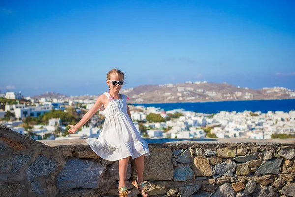 Bedårande liten flicka i Mykonos stad bakgrund fantastisk utsikt över traditionella vita hus — Stockfoto