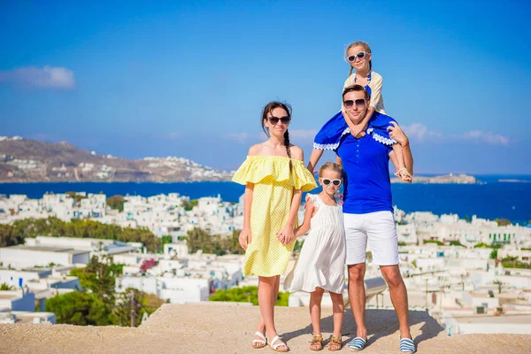 Avrupa'nın aile tatili. Ebeveynler ve çocuklar kamera arka plan Mykonos Adası Yunanistan bakarak — Stok fotoğraf