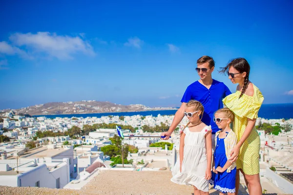 Familjesemester i Europa. Föräldrar och barn att ta selfie foto bakgrund Mykonos stad i Grekland — Stockfoto