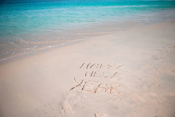 Frohes neues Jahr in den weißen Sand geschrieben — Stockfoto