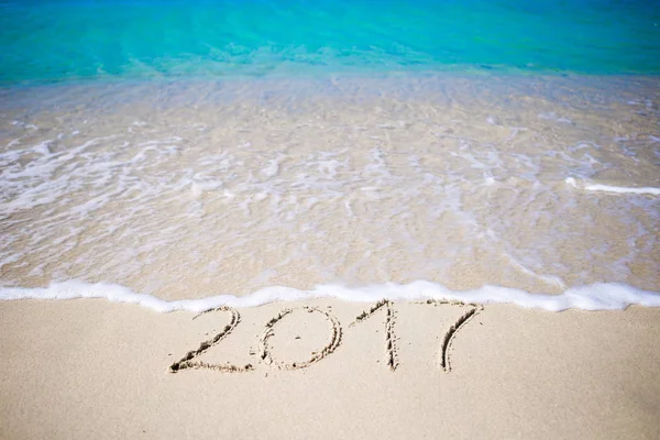 2017 escrito à mão na praia de areia com onda de oceano macio no fundo — Fotografia de Stock