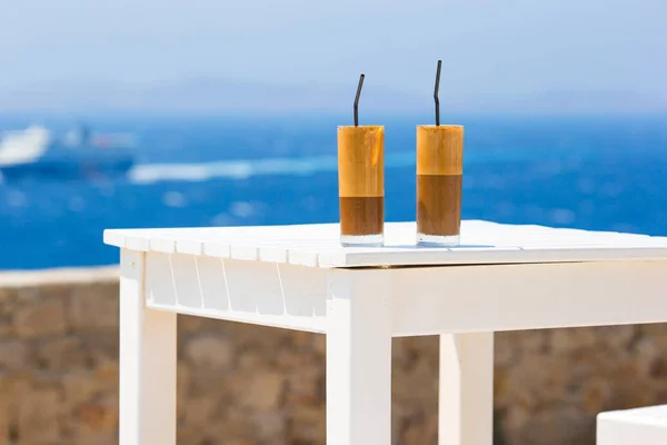 Φραπέ, παγωμένο καφέ στην παραλία. Παγωμένος καφές καλοκαίρι φραπουτσίνο, φραπέ ή latte σε ψηλό ποτήρι φόντο τη θάλασσα στο beach bar — Φωτογραφία Αρχείου