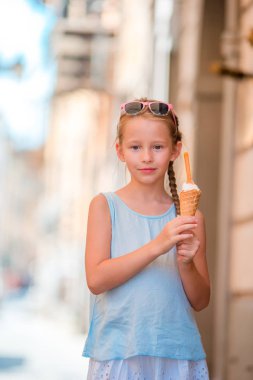 Yazın dışarıda dondurma yiyen sevimli küçük bir kız. Roma 'da Gelateria yakınlarında İtalyan dondurmasının tadını çıkaran tatlı bir çocuk.