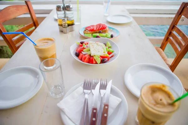 Tradycyjny obiad, pyszne świeże sałatki greckiej i serwowane w porze lunchu w restauracji na świeżym powietrzu z pięknym widokiem na morze i port w brusketa — Zdjęcie stockowe