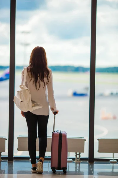 Νεαρή γυναίκα κοντά σε παράθυρο σε μια αίθουσα αναμονής αεροδρομίου, περιμένοντας να φτάσει — Φωτογραφία Αρχείου