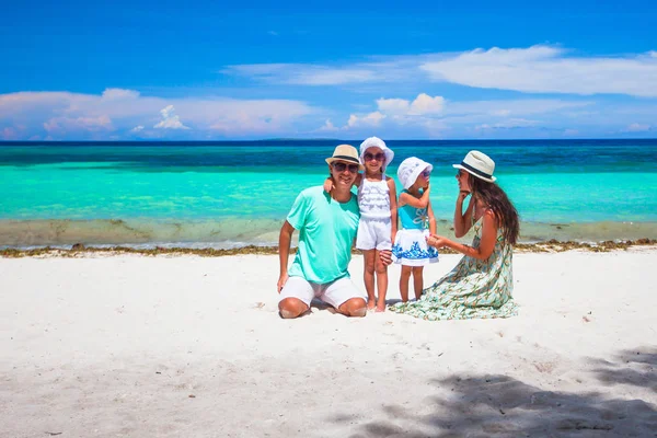 夏休みの間に熱帯のビーチで一緒に歩く子供たちと幸せな美しい家族 — ストック写真