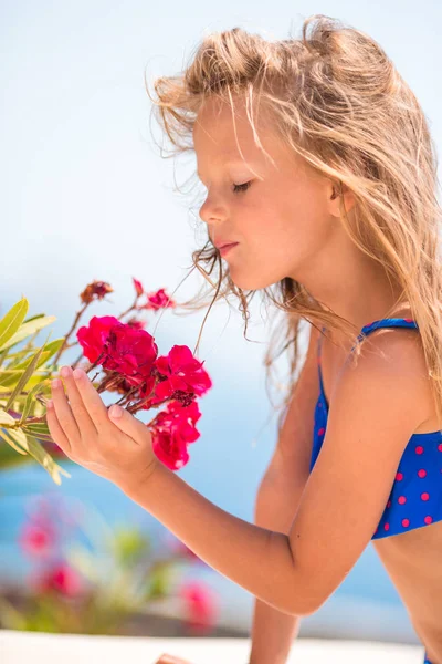 Niña adorable oliendo flores de colores en el día de verano — Foto de Stock