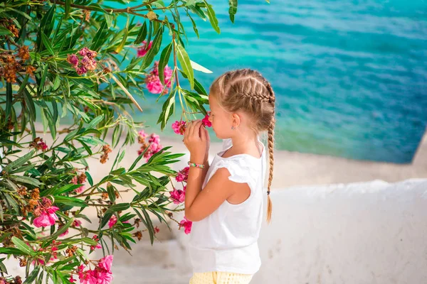 Μικρό αξιολάτρευτο κορίτσι που μυρίζει πολύχρωμα λουλούδια την καλοκαιρινή μέρα — Φωτογραφία Αρχείου