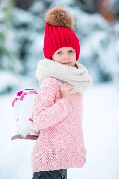 Entzückendes kleines Mädchen, das im Winter im Schnee im Freien Schlittschuh läuft — Stockfoto