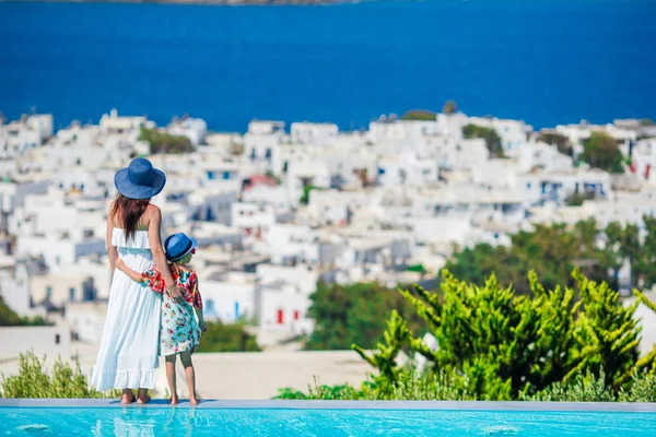 Очаровательная маленькая девочка и молодая мама на краю греческого городка у бассейна на Кикладах, Греция — стоковое фото