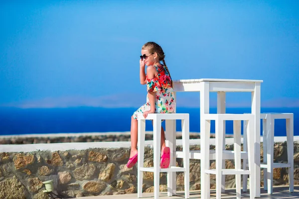 Kid sitting in outdoor cafe with sea view. Time for lunch. — Stock Photo, Image