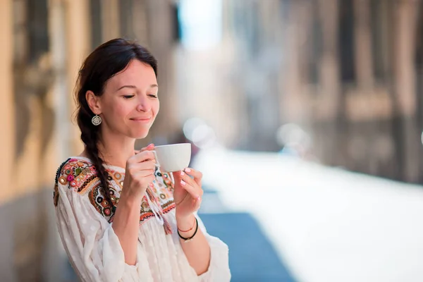 Retrato de hermosa chica con taza de café en la calle. Turista caucásica disfruta de sus vacaciones europeas en ciudad vacía —  Fotos de Stock