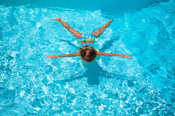 Kleines süßes, glückliches Mädchen schwimmt im Freibad wie ein Star — Stockfoto